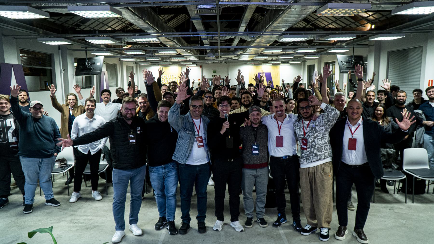 Participantes com as mãos levantadas no fim de uma edição da ClawCon